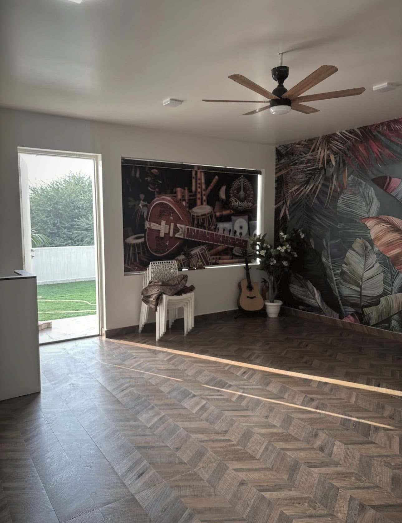 The Antraalaap cultural arts hall — a sitar and tabla mural fills one wall, with an acoustic guitar resting in the corner